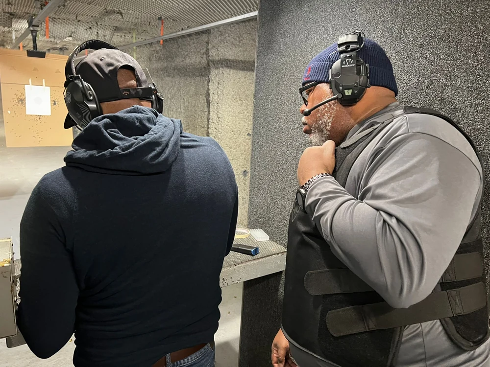 Damon Wright speaking with a student during an indoor range session